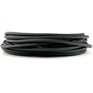 May include: A continuous length of matte black cord coiled into a circular stack. The cord has a smooth, uniform texture and a rounded profile, arranged in multiple overlapping layers to form a compact, cylindrical shape against a white background.