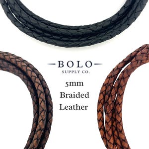 May include: Close-up of three braided leather cords in black, brown, and tan. The text "- BOLO - SUPPLY CO." is above the text "5mm Braided Leather". The cords are tightly woven and appear to be high-quality.