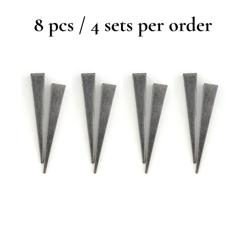 May include: Eight grey metal triangle-shaped objects arranged in pairs on a white background. The text "8 pcs / 4 sets per order" is at the top of the image.