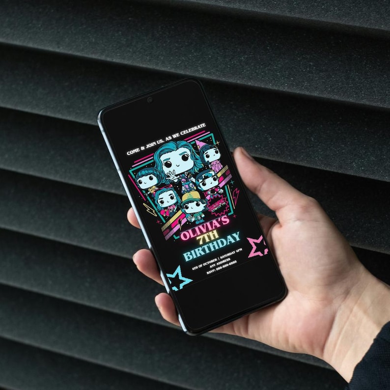 May include: A black smartphone displays a birthday invitation. The invitation features cartoon characters and the text "Olivia's 7th Birthday" in pink and teal. The phone is held against a dark, textured background.