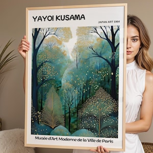 May include: A rectangular art print in a light wood frame featuring a forest scene with dark blue trees, teal foliage, and gold accents. The text YAYOI KUSAMA, JAPAN ART 1964, and Musée d'Art Moderne de la Ville de Paris is printed in black.
