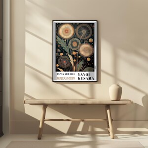 May include: A framed art print featuring a botanical illustration of stylized dandelions in shades of gold, brown, and green against a dark background. The print includes text at the bottom: "JAPAN ART 1921 YAYOI KUSAMA" and Japanese characters.