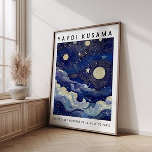 May include: A framed art print featuring a starry night scene with a dark blue sky, yellow moons, and white stars. The print includes the text "YAYOI KUSAMA" at the top and "MUSÉE D'ART MODERNE DE LA VILLE DE PARIS" at the bottom.