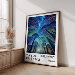 May include: A framed art print showcasing a colourful depiction of trees reaching towards a starry night sky. The artwork includes the artist's name, Yayoi Kusama, and Japanese text. The print is displayed on a wooden floor, leaning against a white wall.