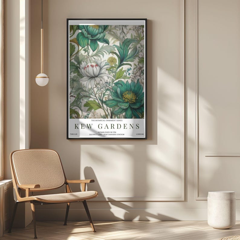 K&ouml;nnte beinhalten: Gerahmter Kunstdruck mit floralem Design in T&uuml;rkis und Wei&szlig;. Der Druck zeigt den Text "KEW GARDENS". Das Kunstwerk h&auml;ngt an einer beigen Wand. Der Raum umfasst einen Stuhl und eine dekorative Leuchte. Botanische Ornament-Serie.