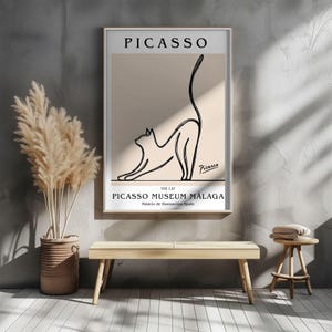 Puede incluir: Una impresi&oacute;n art&iacute;stica enmarcada con un dibujo lineal minimalista de un gato estir&aacute;ndose. La impresi&oacute;n incluye el texto "PICASSO" en la parte superior y "PICASSO MUSEUM M&Aacute;LAGA" en la parte inferior, con la firma del artista.
