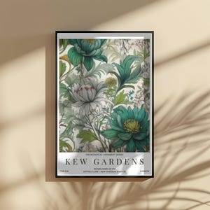 K&ouml;nnte beinhalten: Gerahmter botanischer Druck mit einem floralen Design mit t&uuml;rkis-wei&szlig;en Blumen und gr&uuml;nen Bl&auml;ttern. Der Druck enth&auml;lt den Text "KEW GARDENS" und "LONDON". Teil der "THE BOTANICAL ORNAMENT SERIES".