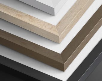 May include: A stack of four rectangular picture frames with white matting. The frames are arranged in a descending order featuring a white finish, a light natural wood grain, a medium brown wood tone, and a solid matte black finish.