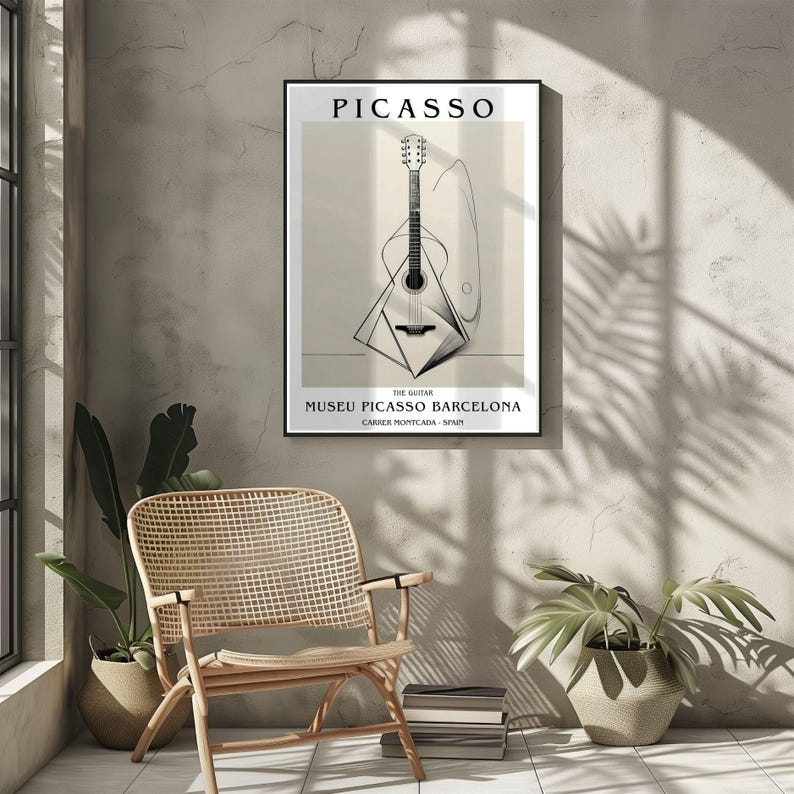 Puede incluir: Un p&oacute;ster enmarcado con una ilustraci&oacute;n en blanco y negro de una guitarra, con el nombre "PICASSO" en la parte superior. El texto "MUSEU PICASSO BARCELONA" est&aacute; en la parte inferior. El p&oacute;ster est&aacute; colgado en una pared de color neutro.
