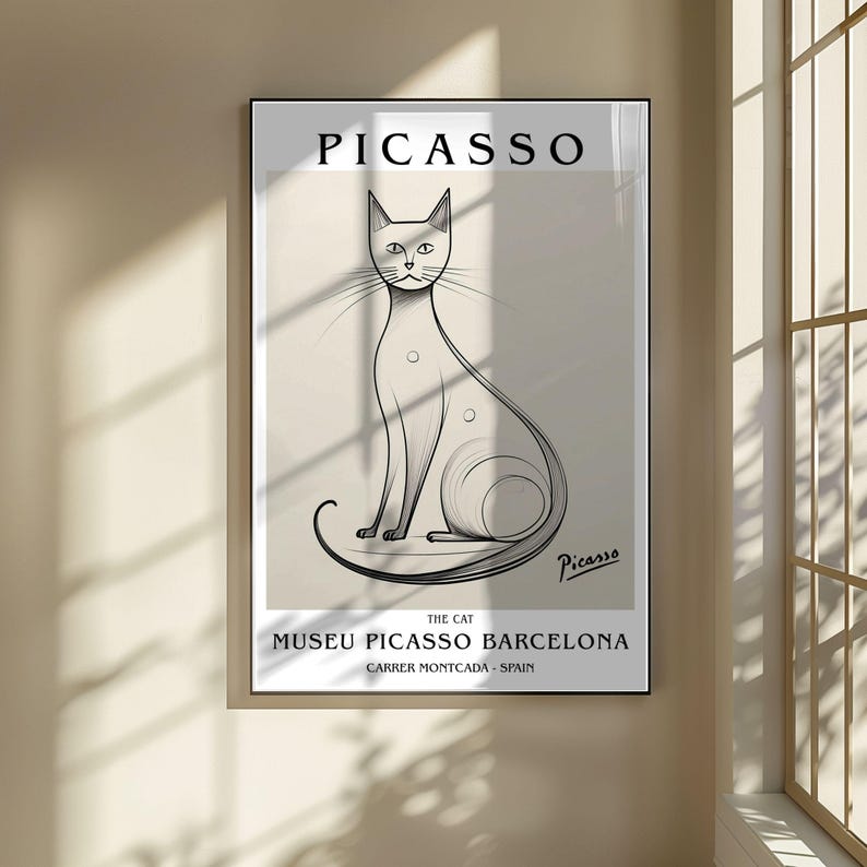 May include: A framed art print featuring a Picasso sketch of a cat. The artwork is in black and white, with the name "Picasso" at the top and the text "Museu Picasso Barcelona" at the bottom. The cat is depicted with long lines and a minimalist style.