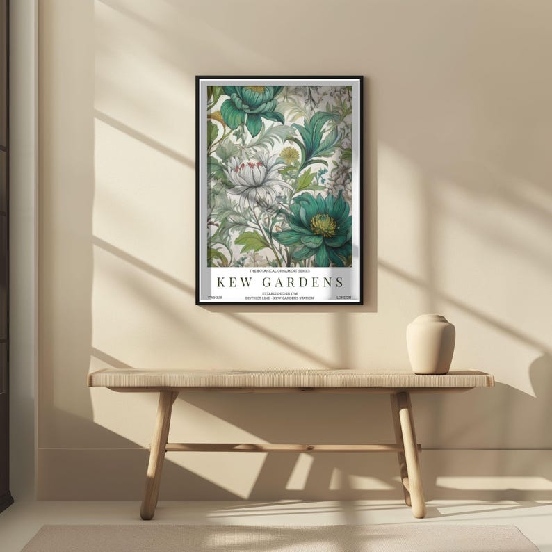 K&ouml;nnte beinhalten: Ein gerahmter Kunstdruck mit einem floralen Design mit t&uuml;rkisfarbenen und wei&szlig;en Blumen und gr&uuml;nen Bl&auml;ttern. Der Druck tr&auml;gt die Aufschrift "KEW GARDENS". Das Kunstwerk wird &uuml;ber einer Holzbank ausgestellt.