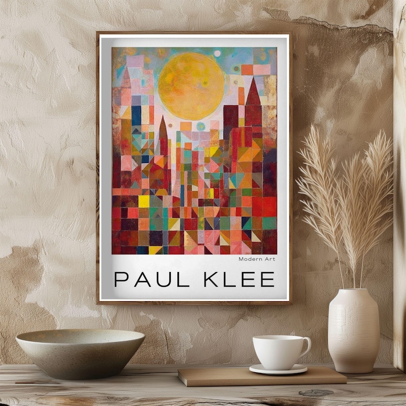 Peut inclure: Une affiche encadr&eacute;e d'un paysage urbain abstrait color&eacute; de Paul Klee. L'&oelig;uvre pr&eacute;sente des formes g&eacute;om&eacute;triques rouges, jaunes, bleues et vertes, avec un grand soleil jaune. Le texte "PAUL KLEE" et "Modern Art" sont affich&eacute;s.