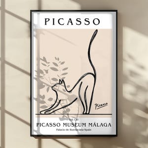 Puede incluir: L&aacute;mina art&iacute;stica enmarcada con un dibujo lineal negro de un gato estir&aacute;ndose. La l&aacute;mina incluye el nombre "Picasso" en la parte superior y "Picasso Museum M&aacute;laga" en la parte inferior. El gato es negro y el fondo es beige claro.