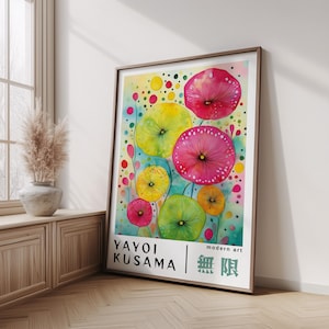 Peut inclure: Une affiche encadrée présentant des fleurs abstraites colorées dans des tons de rose, jaune et vert. L'œuvre comprend le texte "YAYOI KUSAMA" et "modern art" avec des caractères japonais. L'affiche est exposée dans une pièce avec de la lumière naturelle.