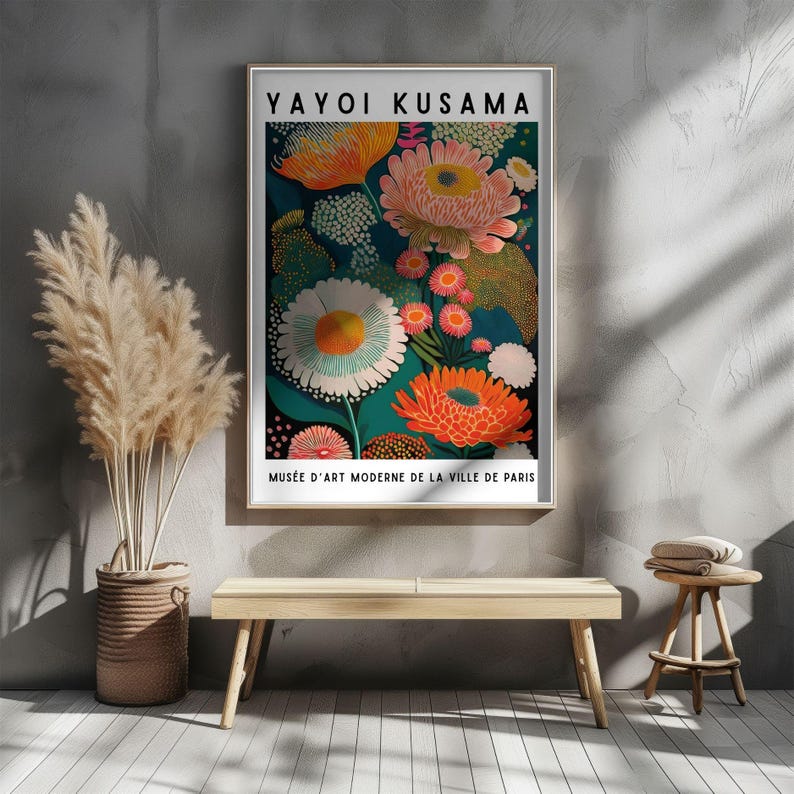 Pode incluir: Uma impress&atilde;o art&iacute;stica emoldurada com um design floral colorido de Yayoi Kusama. A obra de arte apresenta grandes flores estilizadas em tons de laranja, rosa, branco e verde-azulado sobre um fundo escuro. O texto "Yayoi Kusama" e "Mus&eacute;e d'Art Moderne de la Ville de Paris" s&atilde;o vis&iacute;veis.
