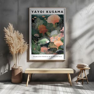 May include: A framed art print featuring a colorful underwater scene with coral, fish, and aquatic plants. The print includes the text "YAYOI KUSAMA" at the top and "Mus&eacute;e d'Art Moderne de la Ville de Paris" at the bottom. The artwork is displayed on a gray wall.
