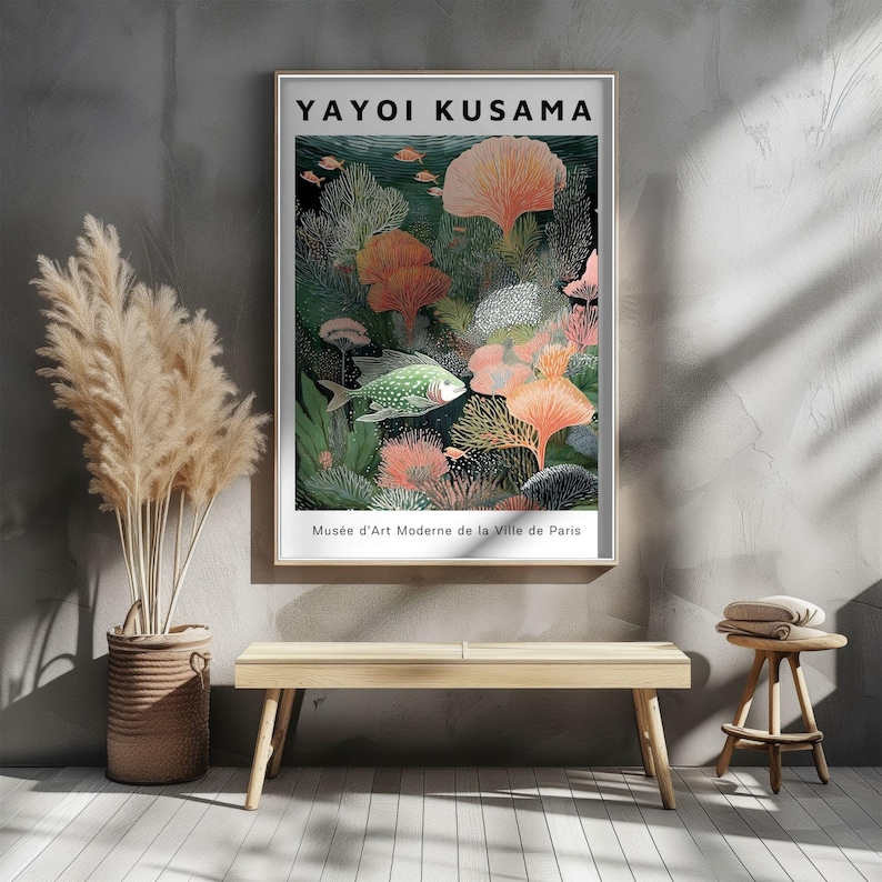 May include: A framed art print featuring a colorful underwater scene with coral, fish, and aquatic plants. The print includes the text "YAYOI KUSAMA" at the top and "Mus&eacute;e d'Art Moderne de la Ville de Paris" at the bottom. The artwork is displayed on a gray wall.