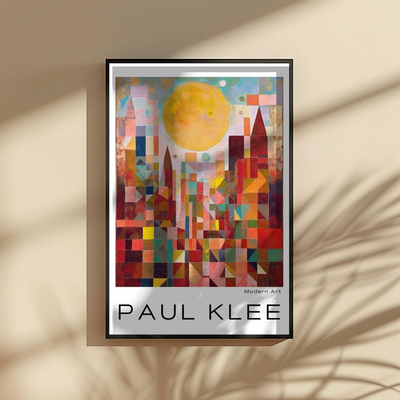 Peut inclure: Impression d'art encadr&eacute;e d'un paysage urbain color&eacute; avec un grand soleil jaune. L'&oelig;uvre, intitul&eacute;e "PAUL KLEE", pr&eacute;sente des formes g&eacute;om&eacute;triques rouges, oranges, bleues et vertes. Les mots "Modern Art" sont &eacute;galement visibles.