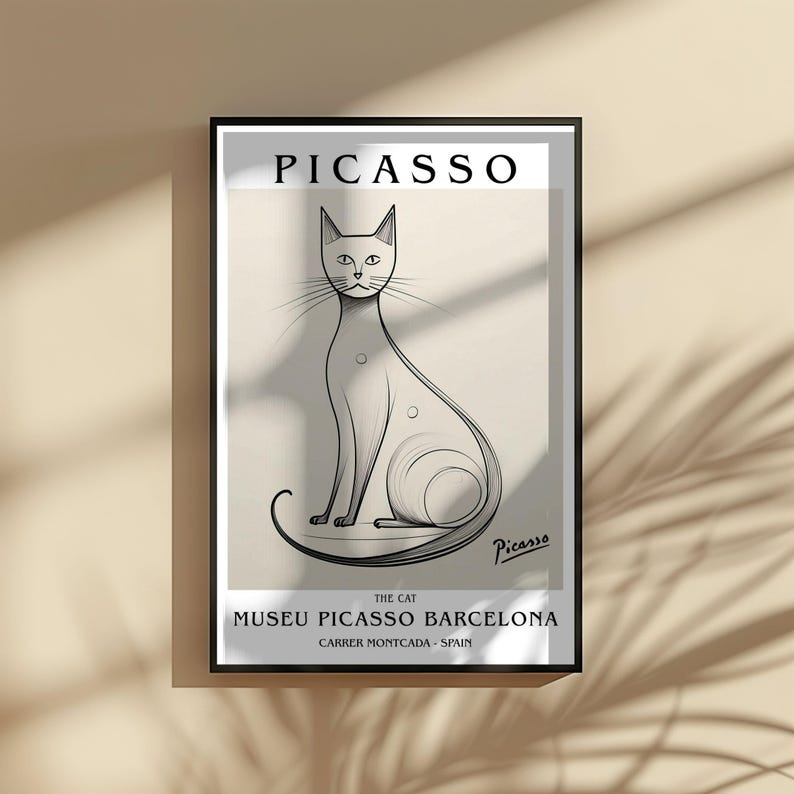 May include: Framed art print featuring a stylized black and white illustration of a cat, with the name "Picasso" at the top. The print includes the text "The Cat" and "Museu Picasso Barcelona, Carrer Montcada - Spain."