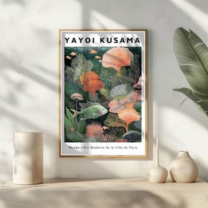 May include: Framed art print featuring a colorful underwater scene with fish and coral. The print includes the text "YAYOI KUSAMA" at the top and "Mus&eacute;e d'Art Moderne de la Ville de Paris" at the bottom. The artwork is displayed on a light-colored wall.