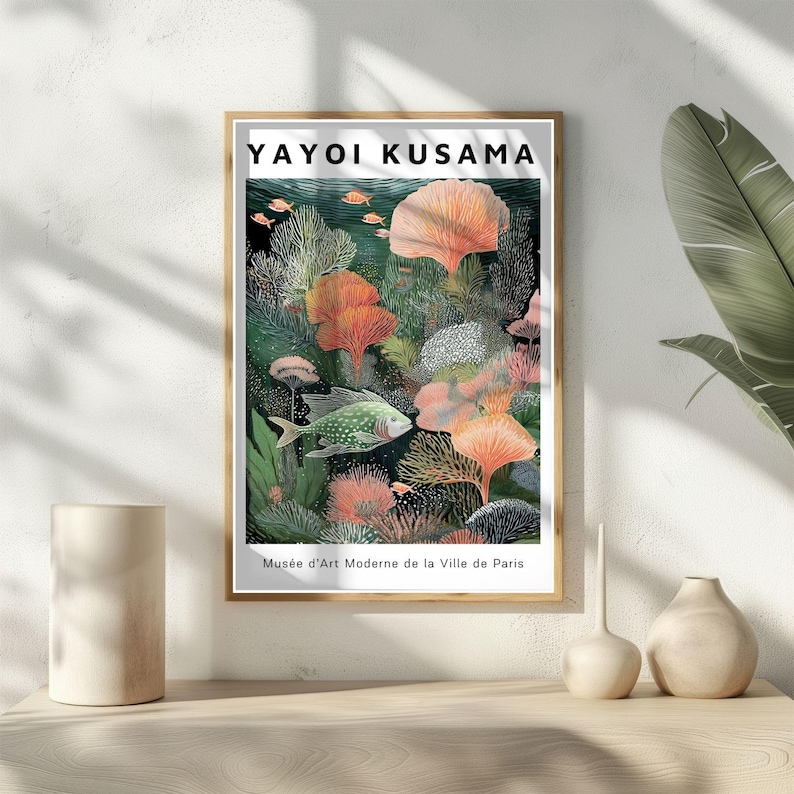 May include: Framed art print featuring a colorful underwater scene with fish and coral. The print includes the text "YAYOI KUSAMA" at the top and "Mus&eacute;e d'Art Moderne de la Ville de Paris" at the bottom. The artwork is displayed on a light-colored wall.