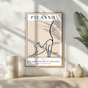 Puede incluir: Una impresi&oacute;n art&iacute;stica enmarcada con un dibujo lineal minimalista de un gato estir&aacute;ndose. La impresi&oacute;n incluye el nombre "PICASSO" en la parte superior, con "THE CAT" y "PICASSO MUSEUM M&Aacute;LAGA" debajo. La obra de arte est&aacute; en un marco dorado.