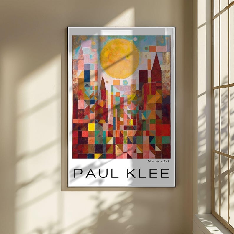 Peut inclure: Impression d'art encadr&eacute;e repr&eacute;sentant une ville abstraite color&eacute;e avec un grand soleil jaune. L'&oelig;uvre, intitul&eacute;e &laquo; PAUL KLEE &raquo; et &laquo; Art Moderne &raquo;, pr&eacute;sente des formes g&eacute;om&eacute;triques aux couleurs vives, notamment le rouge, l'orange et le bleu. L'impression est affich&eacute;e sur un mur beige.