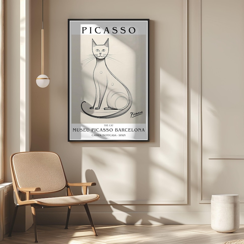May include: A framed art print featuring a Picasso cat illustration. The artwork is in black and white, with the name "Picasso" at the top and "Museu Picasso Barcelona" at the bottom. The cat is stylized with long lines.