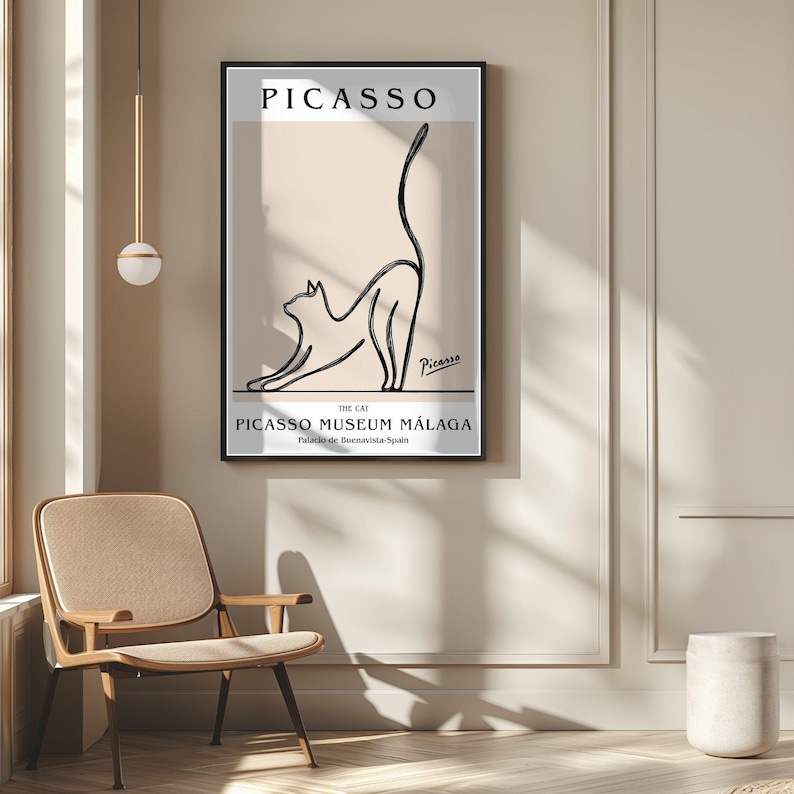 Puede incluir: Un cuadro enmarcado con un dibujo lineal negro minimalista de un gato estir&aacute;ndose. El cuadro incluye el nombre "Picasso" y el texto "Picasso Museum M&aacute;laga". La obra de arte se exhibe en una pared beige.