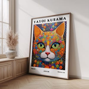 Pode incluir: Uma impressão de arte emoldurada com um retrato de gato colorido. A obra de arte, de Yayoi Kusama, mostra o rosto de um gato com vibrantes bolinhas laranja, azul, verde e amarelo. O texto "TOKYO JAPAN 1985 Modern Art" é visível.