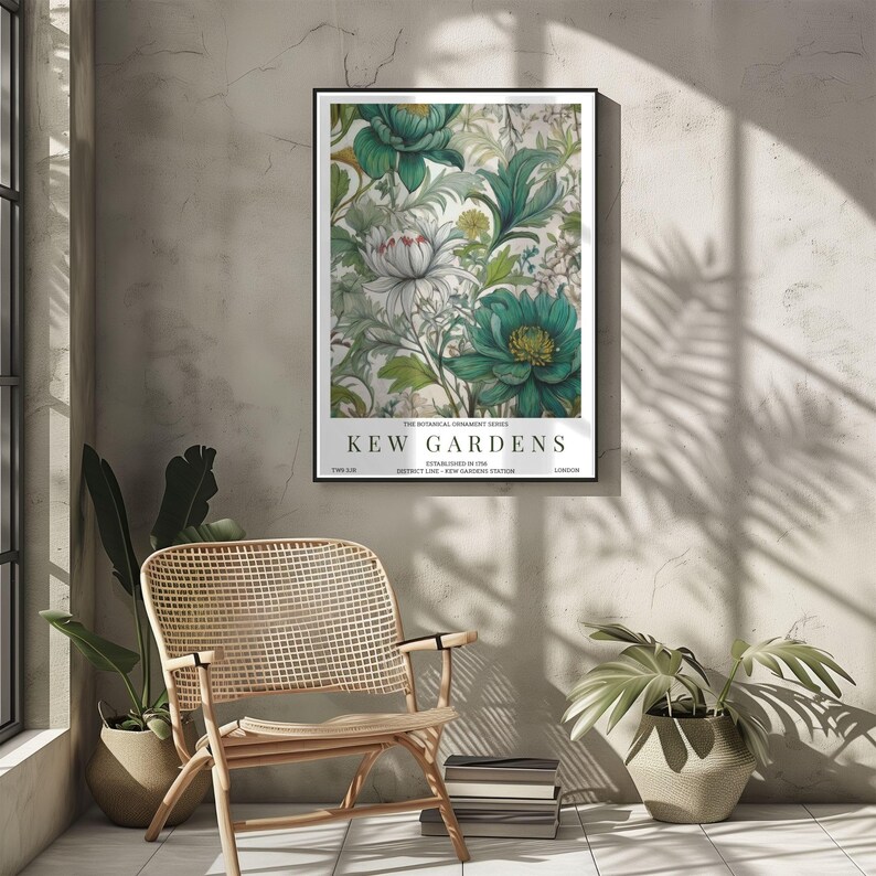 K&ouml;nnte beinhalten: Ein gerahmter botanischer Druck mit einem floralen Design in T&uuml;rkis und Wei&szlig;. Der Druck tr&auml;gt die Aufschrift "KEW GARDENS" und weitere Details. Der Druck wird an einer neutralen Wand mit einem Korbstuhl und Pflanzen im Vordergrund gezeigt.