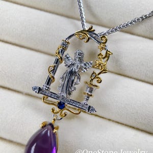 May include: A silver and gold pendant necklace with an angel design within a decorative frame. The pendant features a large, teardrop-shaped, purple gemstone. The necklace is on a silver chain. The text "@OneStone Jewelry" is visible.