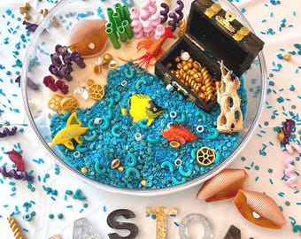 Cestino sensoriale a tema oceano: forziere del tesoro dei pirati dipinto a mano, pasta modellabile, animali marini, tappetino per attività.