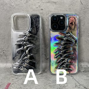May include: Two clear phone cases with a spine-like design. One case has a black and white marbled background, and the other has a colorful, iridescent background. The spine design is silver and three-dimensional.