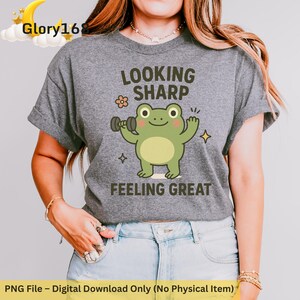 May include: Gray t-shirt with a green frog lifting weights and the text "Looking Sharp Feeling Great".