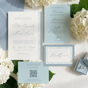 Könnte beinhalten: Eine Hochzeits-Suite in Hellblau und Weiß, bestehend aus einer Einladung, einer RSVP-Karte und einer Detailkarte. Das Design zeigt elegante Schrift und florale Muster. Eine Ringbox mit einem Diamantring ist ebenfalls vorhanden.