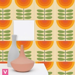 Op de afbeelding: Een set van negen retro-stijl keramische tegels met een herhalend patroon van oranje, gele en groene bloemen. De tegels zijn in een rasterpatroon gerangschikt en zijn perfect om een ​​touch van vintage stijl aan elke kamer toe te voegen.