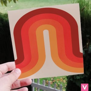 Può includere: Una stampa in stile retrò con un design arcobaleno multicolore. L'arcobaleno è composto da strisce rosse, arancioni, gialle e marroni. La stampa è su uno sfondo color crema.