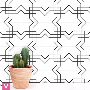 Peut inclure: Un carreau blanc avec un motif géométrique noir. Le carreau présente un motif répétitif d'étoiles et de carrés. Une petite plante de cactus en pot se trouve au premier plan.