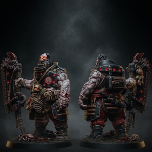 Può includere: Figura in miniatura dettagliata di un guerriero pesantemente corazzato, con tatuaggi intricati, un volto a forma di teschio e accenti rossi luminosi. La figura tiene in mano una grande arma meccanica con un bordo a forma di sega. Il guerriero indossa abiti rossi e neri.