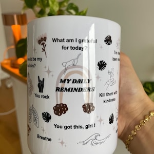 Hand holding an affirmations mug mental health