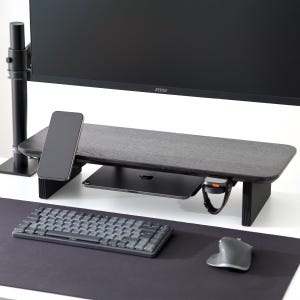 May include: A dark wood monitor stand with a black computer monitor, a smartphone, and a tablet. A wireless keyboard and mouse are on a black desk mat. A smartwatch is attached to the stand.