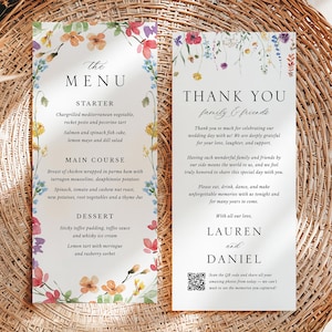 Peut inclure: Un menu de mariage et une carte de remerciements avec des motifs floraux en aquarelle. Le menu comprend une entrée, un plat principal et un dessert. La carte de remerciements exprime la gratitude à la famille et aux amis pour leur présence au mariage. La carte comprend un code QR pour accéder aux photos du mariage.