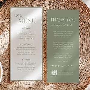 Peut inclure: Deux cartons de menu de mariage vert clair. Le carton de gauche affiche "The MENU" et une liste de plats. Le carton de droite dit "THANK YOU family & friends" avec un message de remerciement, des noms et un code QR. Les cartes sont sur une surface tissée.