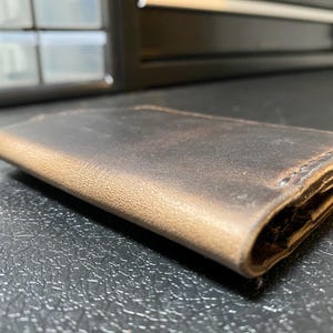 Cartera de cuero marrón cosida a mano