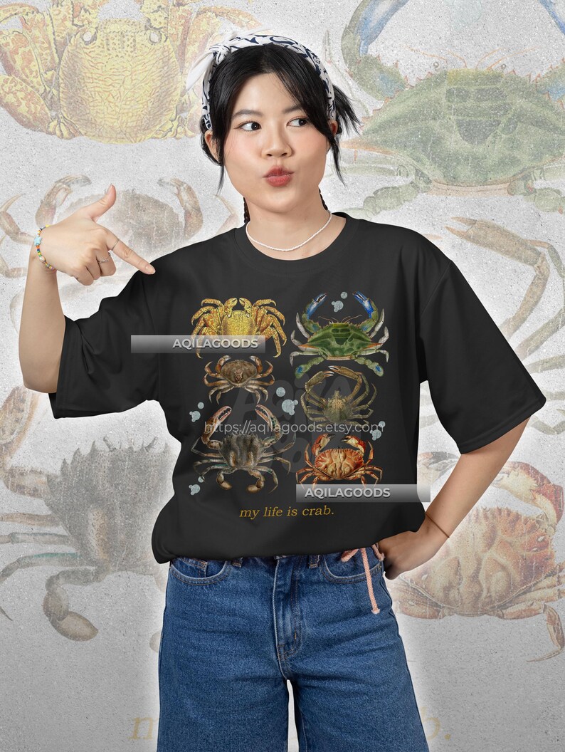 May include: Black t-shirt featuring a collage of crab illustrations in various colors. The shirt includes the text "my life is crab" and the shop's URL. The crabs are depicted in shades of yellow, green, brown, and red, creating a vintage aesthetic.