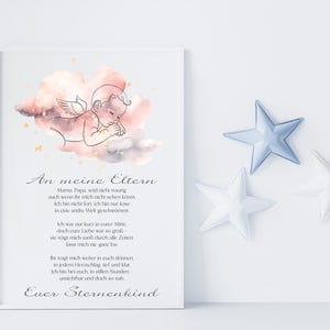 Può includere: Una stampa incorniciata con un'illustrazione ad acquerello di un angelo in una nuvola, con testo in tedesco. Tre decorazioni a forma di stella in peluche azzurro e bianco sono a destra della cornice. La stampa è un oggetto commemorativo.