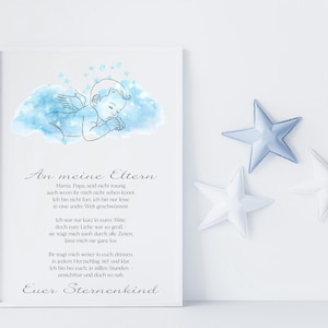 Puede incluir: Una impresión enmarcada con texto en alemán y una ilustración de acuarela de un ángel bebé sobre una nube azul. Junto al marco hay tres cojines decorativos en forma de estrella, dos blancos y uno azul claro.