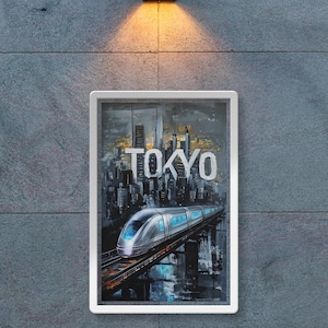 Può includere: Una stampa artistica incorniciata raffigurante un treno ad alta velocità a Tokyo, in Giappone, sullo sfondo di un paesaggio urbano. La parola "TOKYO" è in bianco. L'opera è montata su un muro di pietra grigia, con un moderno apparecchio di illuminazione sopra.