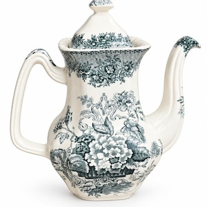 Op de afbeelding: Een crèmekleurige keramische theepot met een donkergroen bloemenpatroon in transferdruk. De theepot heeft een hoog, hoekig handvat, een gebogen tuit en een bijpassend deksel met een puntige knop. Het lichaam is versierd met gedetailleerde botanische illustraties van bloemen en bladeren.